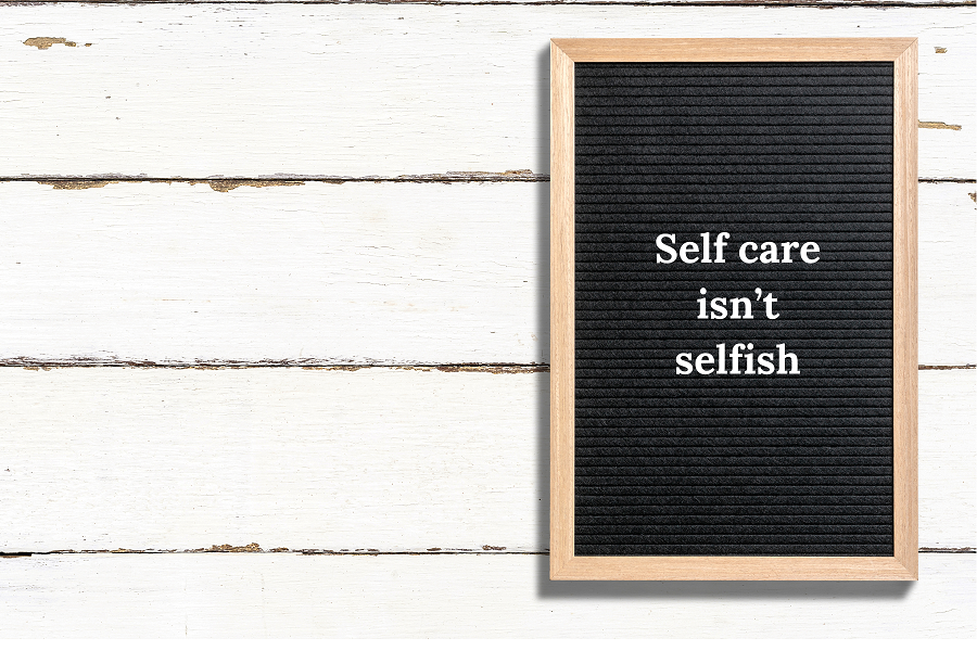 photo of a letterboard with the words "self care isn't selfish"
