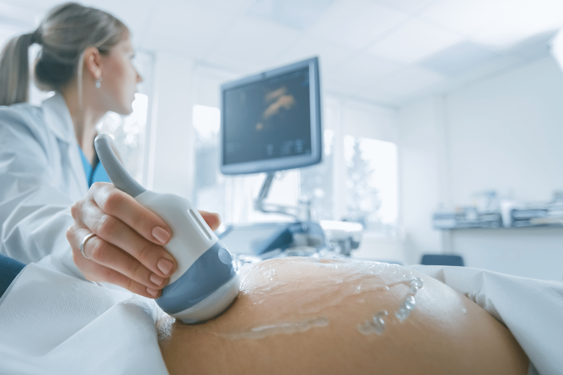 Side view of a pregnant white woman getting an ultrasound.