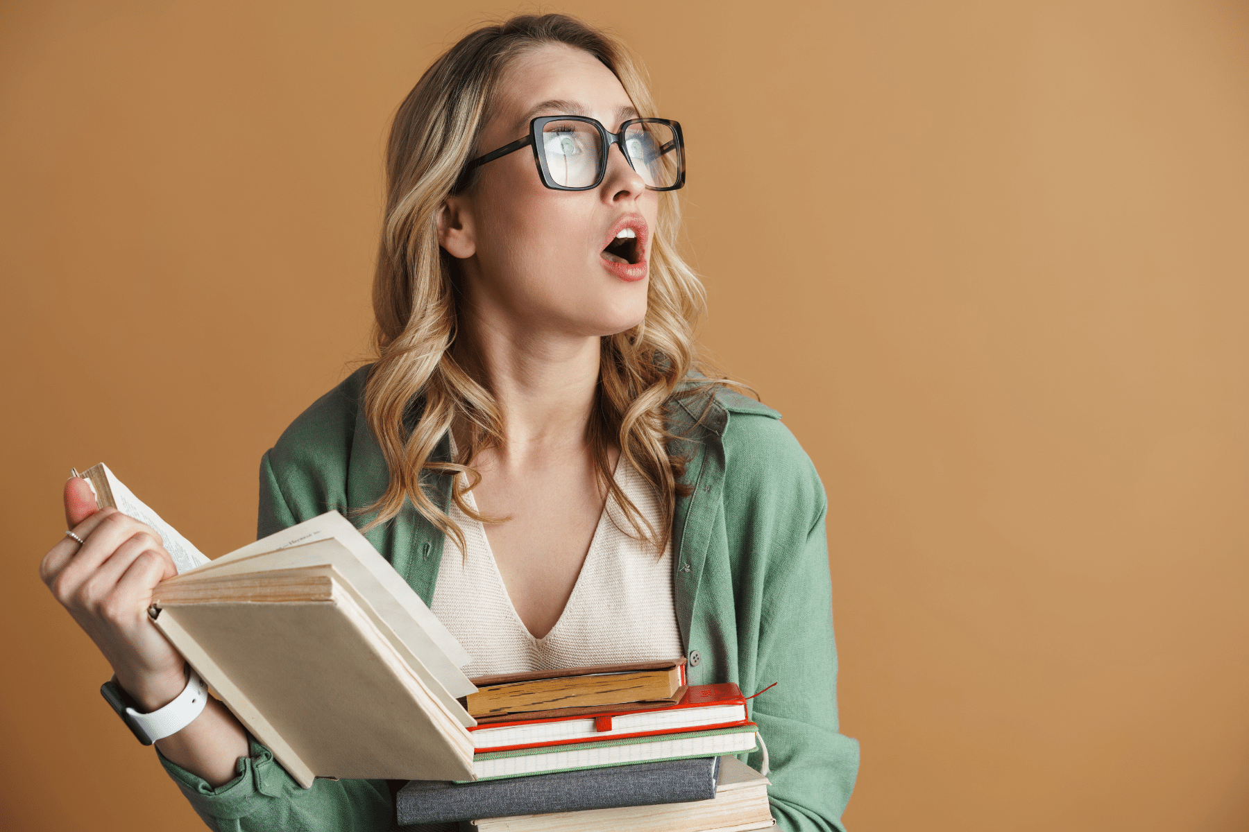 picture of a young woman looking shocked holding a bunch of books