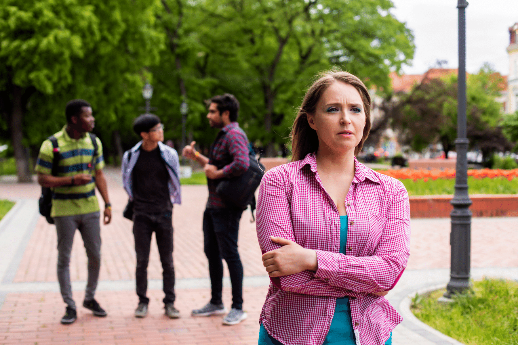 woman with arms crossed in pink and college students standing behind her